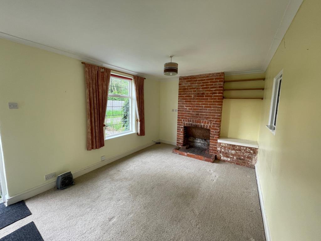 Lot: 20 - THREE-BEDROOM COTTAGE FOR IMPROVEMENT - Living room with fireplace and window to front
